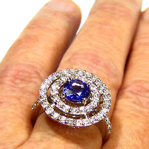 Stunning all natural Tanzanite surrounded by a wall of diamonds in this 14k white gold ring